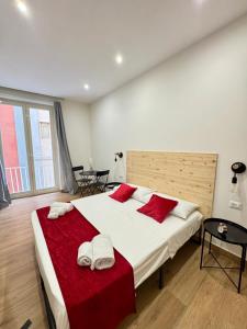 a bedroom with a large white bed with red pillows at Neapolitan Suites in Naples