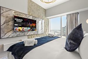 a bedroom with a large bed with a tv on the wall at Desert Key - Platinum Apartments in Gate Tower, Al Reem Island in Abu Dhabi