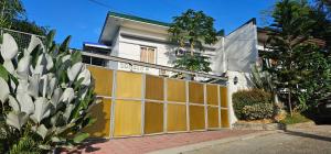 a yellow and white fence in front of a house at Corben's Place in Sampong