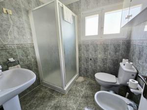 un bagno con doccia, WC e lavandino di Apartamentos Medano - Casa Playa a El Médano Altre 27 foto