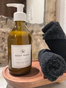a bottle of body wash sitting on a wooden board at UTSKIN By ZENDA - Luxury Villas & Private Pools in Tulum
