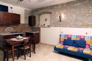 eine Küche und ein Wohnzimmer mit einem Tisch und einem Sofa in der Unterkunft Il Casale della Quercia in Assisi