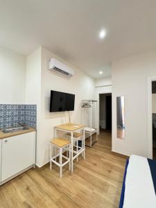 a room with a bed and a desk and a tv at Neapolitan Suites in Naples +12 photos