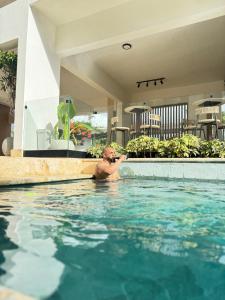 a man in a swimming pool at a hotel at New & Chic 3-Bedroom Penthouse, Punta Cana, Pool-BBQ-Beach Access-Private Rooftop-Padel y Sports amenities in Punta Cana