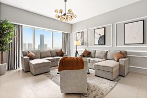 a living room with couches and a chandelier at Desert Key - Platinum Apartments in Gate Tower, Al Reem Island in Abu Dhabi