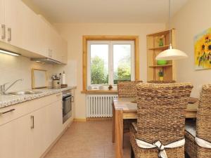 une cuisine avec une table et des chaises et une fenêtre dans l'établissement Süderhof Apartment 2, à Keitum