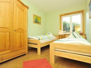 une chambre avec deux lits et une fenêtre dans l'établissement Süderhof Apartment 2, à Keitum