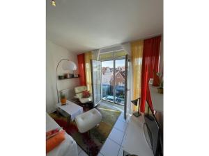 ein Wohnzimmer mit einer weißen Couch und einem Tisch in der Unterkunft Comfort Apartment House Regini in Norderney