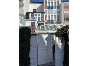 eine weiße Tür in einer Ziegelmauer mit einem Gebäude in der Unterkunft Comfort Apartment House Regini in Norderney