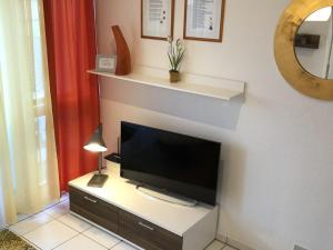 einen Flachbild-TV auf einem Fernsehstand in einem Zimmer in der Unterkunft Comfort Apartment House Regini in Norderney + 14 Fotos