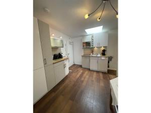 eine Küche mit weißen Schränken und einem Holzboden in der Unterkunft Comfort Apartment House Regini in Norderney