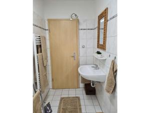 a bathroom with a sink and a wooden door at Watt do you want sea in Sahlenburg