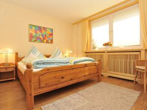 une chambre avec un lit en bois et une fenêtre dans l'établissement Süderhof Apartment 3, à Keitum