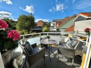 a balcony with a table and chairs and flowers at One-bedroom apartment in Lantershofen +21 photos