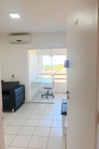 an office with a blue couch and a chair at Ar nos 2 quartos e sala in Imperatriz