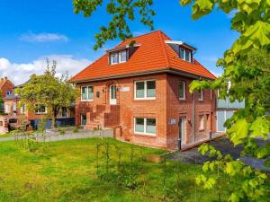 a brick house with an orange roof at Holiday apartment with 2 bedrooms in Greetsiel
