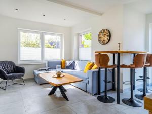 a living room with a blue couch and a table at Holiday apartment with 2 bedrooms in Greetsiel