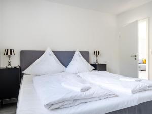 a white bed with white sheets and pillows at Holiday apartment with 2 bedrooms in Greetsiel