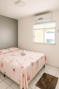 a bedroom with a bed with pink flowers on it at Ar nos 2 quartos e sala in Imperatriz +29 photos