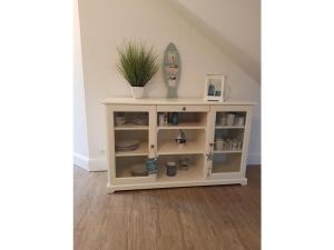 une étagère blanche avec une plante au-dessus dans l'établissement Holiday apartment in Varel with swimming pool, à Dangast