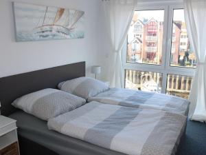 a bedroom with a bed and a large window at Holiday home in Cuxhaven with swimming pool in Cuxhaven