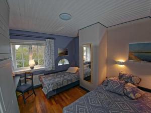 ein Schlafzimmer mit zwei Betten und einem Schreibtisch und einem Fenster in der Unterkunft Schroeders House Kampen House 1C in Kampen