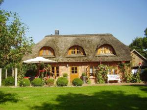 a large stone house with a thatch roof at Luxurious holiday home Room No 7 in Tating
