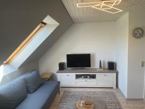 GroßheideにあるOne-bedroom apartmentの青いソファとテレビのあるリビングルーム