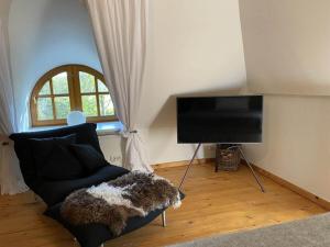 a living room with a couch and a flat screen tv at Luxurious holiday home Room No 7 in Tating