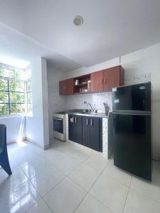 a kitchen with a black refrigerator and a sink at Cómodo apartamento en el rodadero in Rodadero