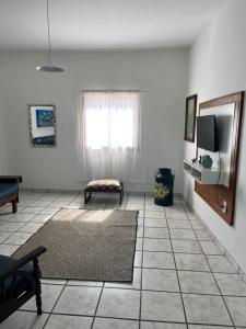 a living room with a window and a rug at Casa 2 quartos praia de Jacaraípe. in Serra