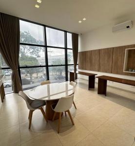 a living room with a table and chairs and a large window at Apartamento Aconchegante e Moderno com Vista Espetacular da Cidade! in Campina Grande