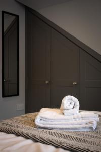 a stack of towels sitting on top of a bed at 2 Bed House - Sleeps 4 - Parking in Devizes