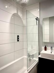 a white bathroom with a shower and a sink at 2 Bed House - Sleeps 4 - Parking in Devizes