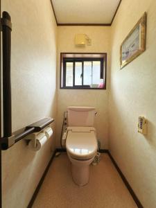a small bathroom with a toilet and a window at CocoGuesthouse in Toyama +35 photos
