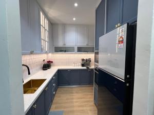 a kitchen with blue cabinets and a refrigerator at Middle Room Only in Bayan Lepas in Bayan Lepas