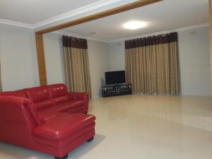 a living room with a red couch and a television at Entire House close to Supermarket gym Restaurants in Melton
