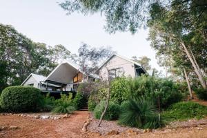 une maison au milieu d'un jardin dans l'établissement Idyll Estate - Bushland Gem with Spa & Tennis Court, à Yallingup Siding