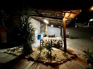 a patio with a table and chairs under a pergola at Casa de Vó in Porto Seguro