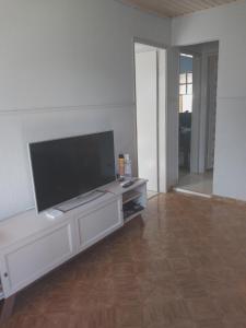 Una sala de estar con un televisor de pantalla plana grande. en Casa Aconchegante, en Nova Odessa 3 fotos más