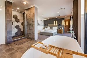 un ampio bagno con vasca e una camera da letto di Front 9 - A Luxury Golf Lovers Getaway a Dunsborough