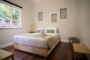 Un dormitorio con una cama con un osito de peluche encima. en Higgins Hideaway - Central Cottage with Garden Oasis, en Margaret River Town