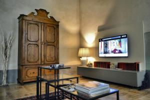 un soggiorno con TV e grande mobile in legno di Roncioni Palace - Soggiorno Adriana a Pisa