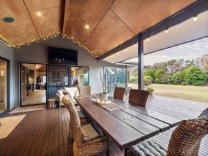 an outdoor dining room with a wooden table and chairs at La Dimora - Tranquil Retreat Where Bush Meets Beach in Prevelly