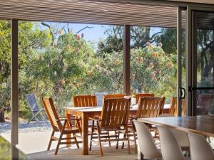 Un comedor con mesa y sillas y una ventana. en Inji Dreaming - Bushland Retreat near Injidup Beach, en Yallingup