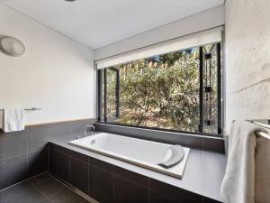 una bañera en un baño con ventana en Inji Dreaming - Bushland Retreat near Injidup Beach, en Yallingup