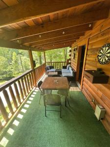Un porche de una cabaña con una mesa y sillas. en Smoky Haven Cabin, en Sevierville