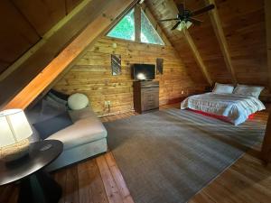 1 dormitorio en una cabaña de madera con 1 cama y 1 sofá en Smoky Haven Cabin, en Sevierville