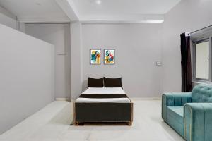 a bedroom with a bed and a blue couch at Hotel O Raj Palace in Bāra Banki