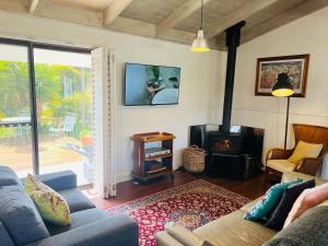 a living room with a couch and a wood stove at The WardRobe Pet Friendly Vintage Vibes at The Seaside in Robe